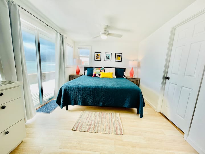 Un espacio luminoso y luminoso con una cama tamaño king, raro en las casas de playa de North Shore.