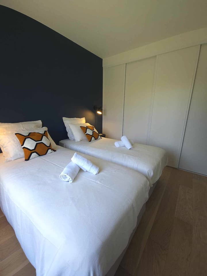 Chambre lumineuse climatisée, dotée de deux lits simples transformables en un grand lit KING SIZE avec surmatelas pour un confort optimal et placard de rangements.