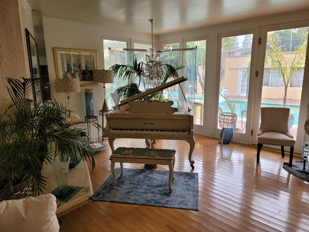 סלון עם פסנתר לתינוק וגישה לחצר החיצונית ולאזור הבריכה.