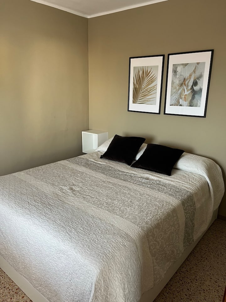 Chambre avec un lit double, rangement dans des tiroirs sous le lit 