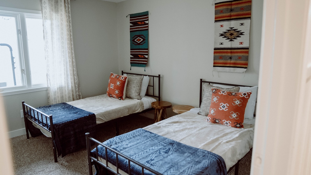 楼下卧室，配有2张单人床和一个衣柜 