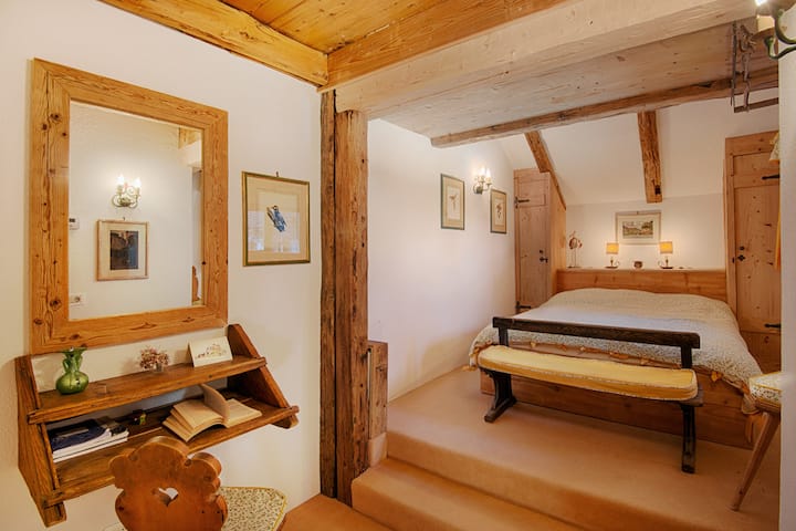 Në katin e parë të chalet, kjo dhomë gjumi ofron një pamje magjepsëse të fshatit të çuditshëm më poshtë. Dritaret kornizojnë skenën piktoreske, duke lejuar që drita natyrale të kaskadojë mbi dhomë. 