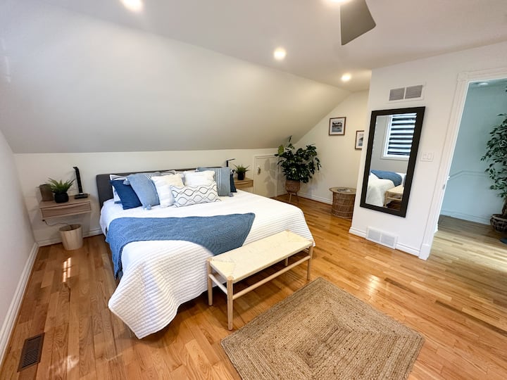 Chambre principale d'escalier avec un lit King Size. Note Night Stands sont équipés de bornes de recharge sans fil. 