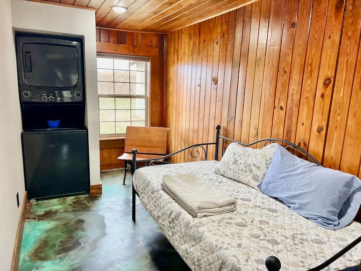 Bedroom #3 doubles as the laundry area and offers a single-sized bed and an old desk paying homage to the historic schoolhouse. 