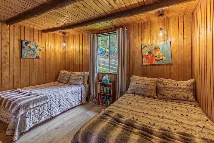 Спална соба со шармантна дрвена ламперија и светли прозорци