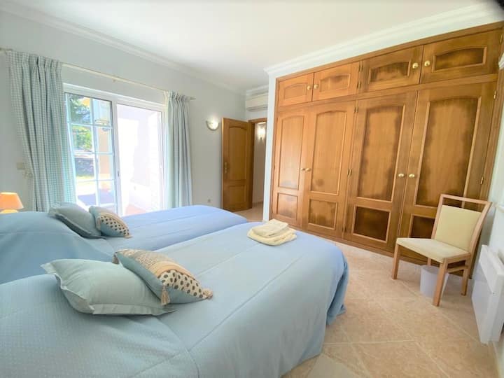 Plava spavaća soba s 2 odvojena kreveta s ugrađenim ormarom otvara se u vrt.