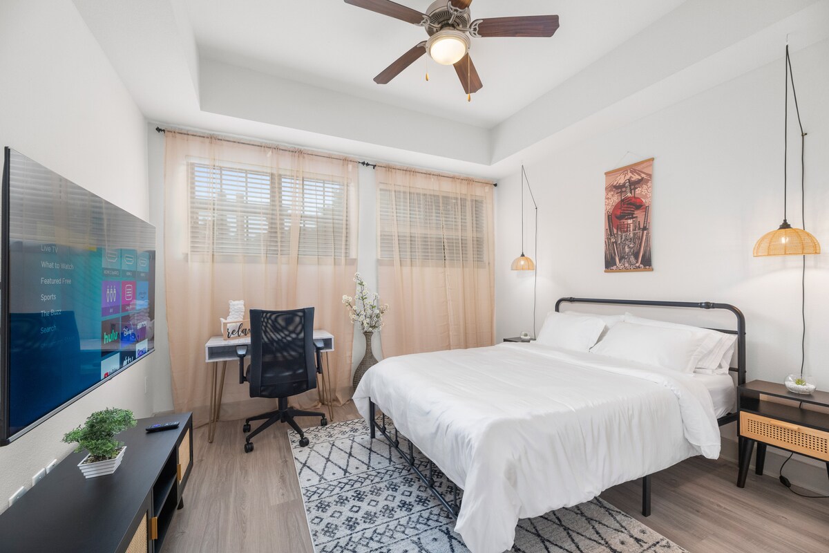 Lit queen size avec un espace de travail dédié et une télévision. Comprend deux tables de chevet.