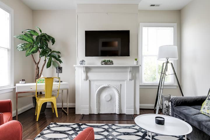 Stylish and cozy living room with a desk, flat-screen Roku TV, full size pull out sofa couch and seating for four.