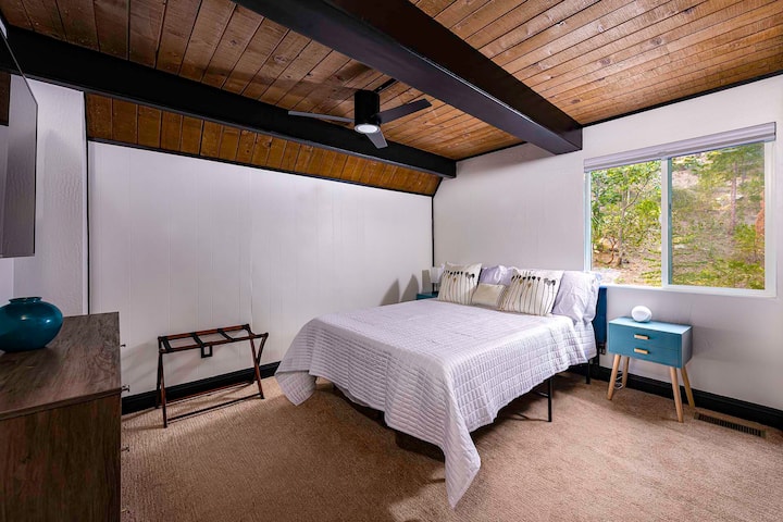 Dhomë gjumi "queen" në nivelin kryesor me shtroja prej pelushi, televizor inteligjent lundrues dhe instalime elektrike të fshehura për një pamje të hijshme. Ventilatori i tavanit e mban hapësirën të freskët, ndërsa pamjet e pyllit dhe shtrojat e rehatshme e bëjnë atë të përsosur për netët çlodhëse pas aventurave malore.