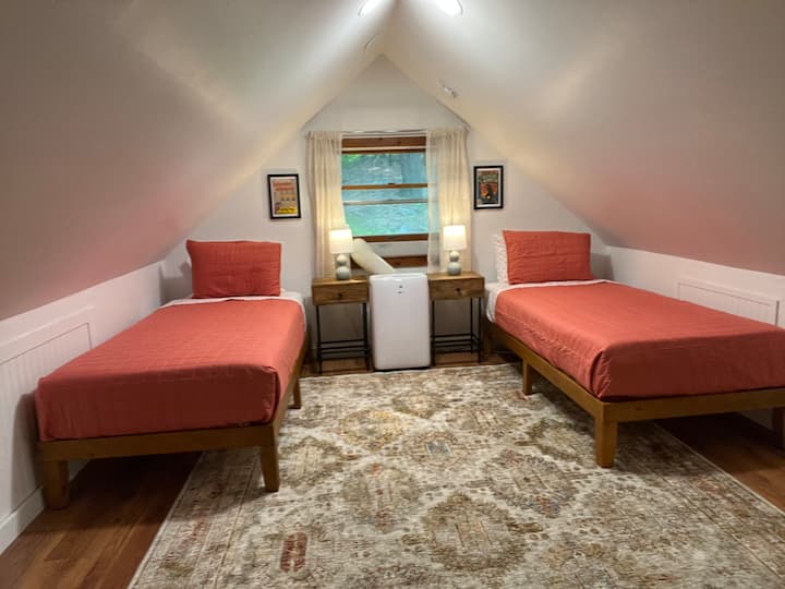 Chumba cha kulala cha roshani (ghorofani) kinafunguliwa kwa sebule hapa chini. Vitanda viwili pacha, Roku TV na A/C. Matandiko ya kijani yanapatikana ikiwa waridi sio kitu chako.