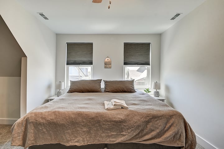 ห้องนอนหลักพร้อมเตียงขนาดคิงไซส์ตั้งอยู่ชั้นบน