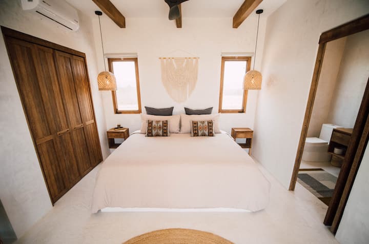 Spálňa s manželskou posteľou King, vankúšmi, klimatizáciou, ventilátorom a výhľadom na oceán.