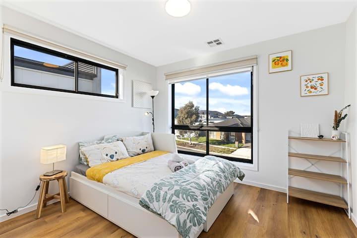 Moderni, puhdas ja tilava makuuhuone 04 yläkerrassa, josta on hiljainen näköala esikaupunkien kadulle ja runsaasti säilytystilaa.