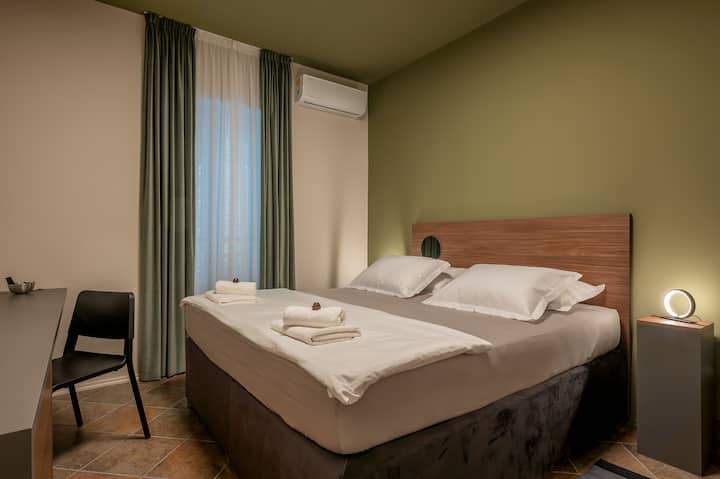 Een slaapkamer met een kingsize bed en een bureau. 