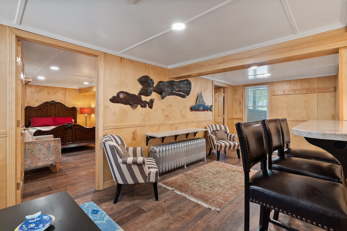 هذه هي منطقة الجلوس وتناول الطعام في الطابق الأرضي التي تظهر مدخل كل من غرفتي النوم في الطابق الأرضي، واحدة تتميز بسرير بحجم كوين وتلفزيون بشاشة مسطحة وخزانة كبيرة، والأخرى عبارة عن سريرين مزدوجين وتلفزيون بشاشة مسطحة وخزانة كبيرة.