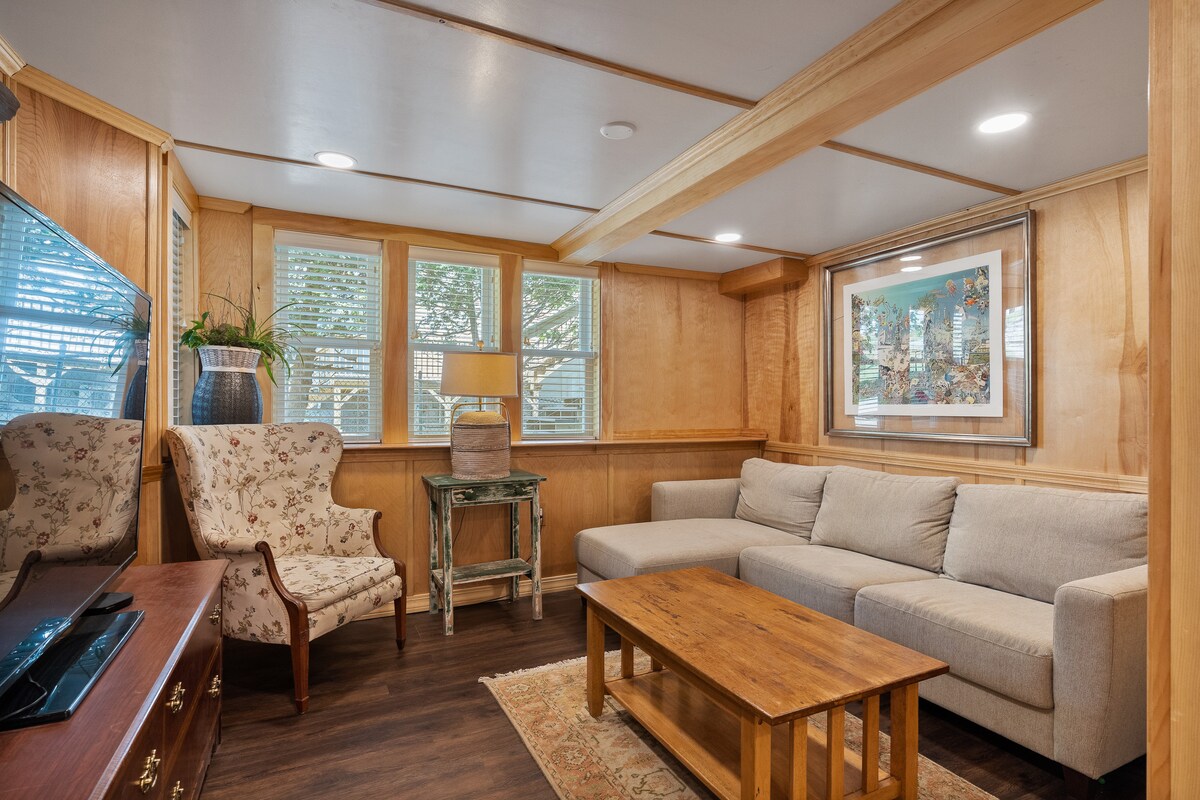 هذه هي غرفة المعيشة المريحة في الطابق الأرضي بشاشة مسطحة عالية وأريكة للنوم.