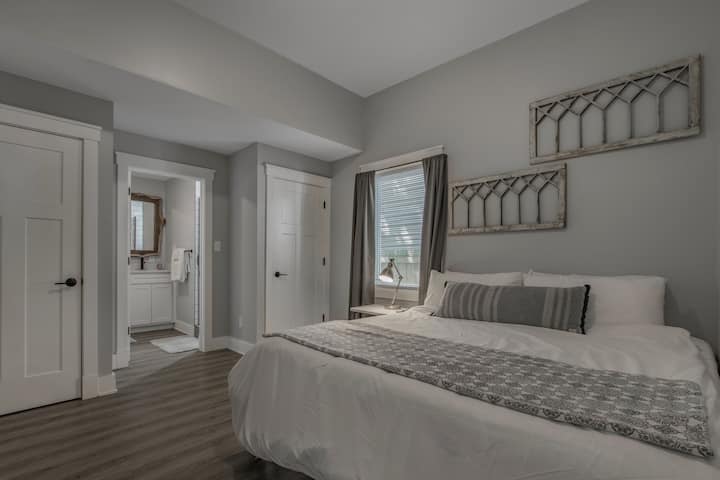 Hoofdslaapkamer met een kingsize bed, een 55 inch smart-tv en een eigen complete badkamer met een inloopdouche.