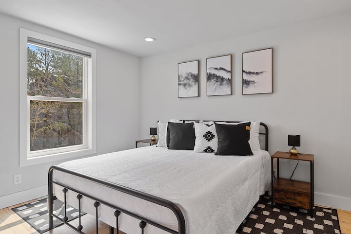 Rangi laini, zisizoegemea upande wowote kwenye kuta huunda mandhari ya kutuliza, huku ukichaguliwa kwa uangalifu vitu vya mapambo na taa huongeza mandhari ya jumla wakati wa kulala kwenye kitanda cha ukubwa wa malkia