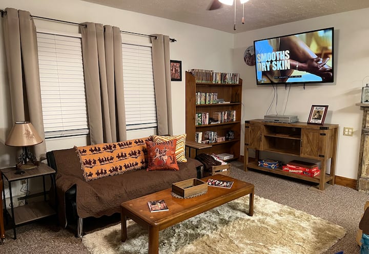 Dnevni boravak. Zapadna tematska svjetiljka i jastuci. Mekani mekani tepih. Kauč se pretvara u mali krevet. Snugly deke. 