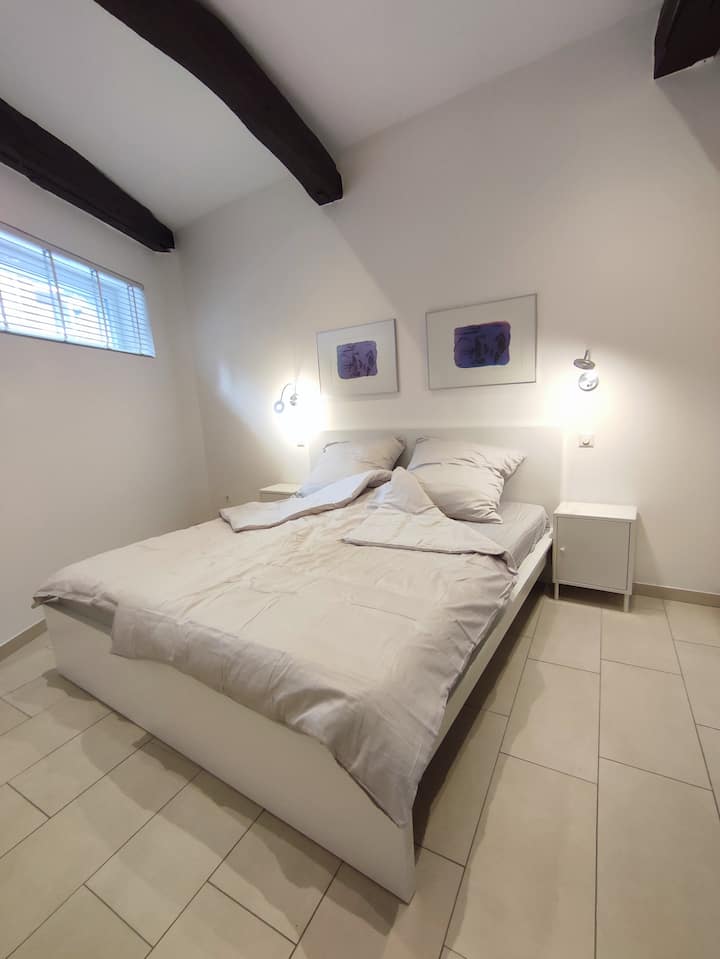 La chambre au rez-de-chaussée avec un lit de 1,80 x 2,00 m et de vieilles poutres du 19ème siècle