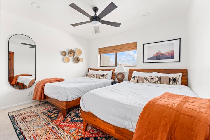 Two queen beds in Bedroom 5, upstairs with cozy bedding.
