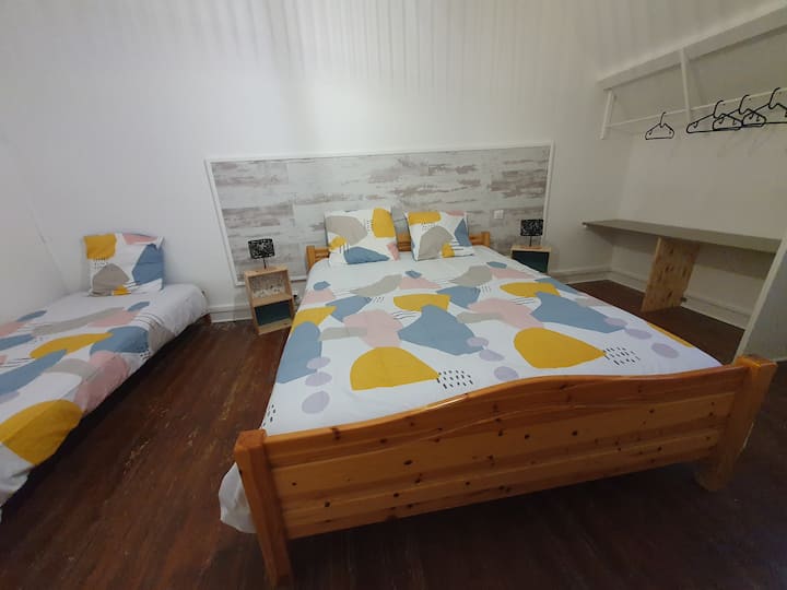 Eléla's 2nd large bedroom with a 160 bed and a single bed, a wardrobe + a storage closet.
We see the sea in the distance 
Shutter + blackout curtain