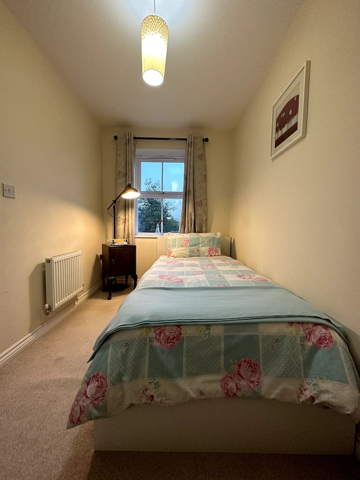 ห้องนอนชั้นแรกพร้อมเตียงเดี่ยวและเครื่องนอนที่สะดวกสบาย