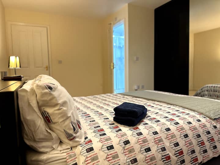 ห้องนอนในตัวชั้นบนสุดพร้อมเตียงขนาดคิงไซส์ที่สะดวกสบายและเครื่องนอนที่อบอุ่น มีตู้เสื้อผ้าบานเลื่อนเต็มรูปแบบพร้อมโรงเก็บของและพื้นที่เก็บของ