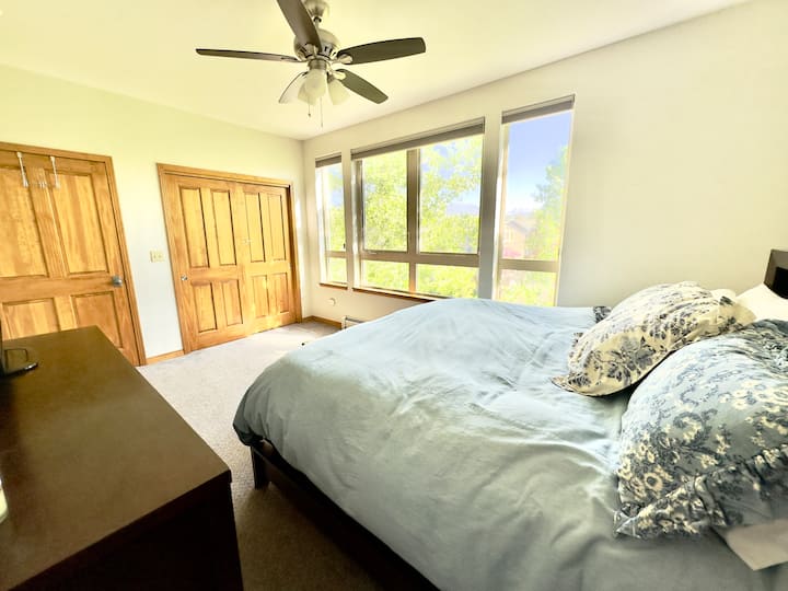 Ruime hoofdslaapkamer met kingsize bed, uitzicht op de bergen en waskast. 