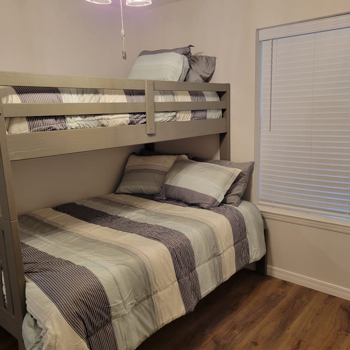 Dormitorio más pequeño fuera de la cocina, extremo opuesto de la casa de los otros tres dormitorios.  Ideal para personas más jóvenes, incluye un colchón Twin Sparrow Signature y un colchón híbrido natural Awara Premier de tamaño completo. 