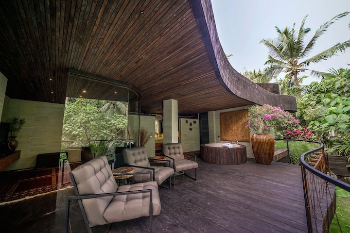 Lower level of Villa Two. Family TV Room (often turned into the 10th bedroom) with the red oriental carpet on the left. Fishbowl Suite entry and bathtub visible on the right.