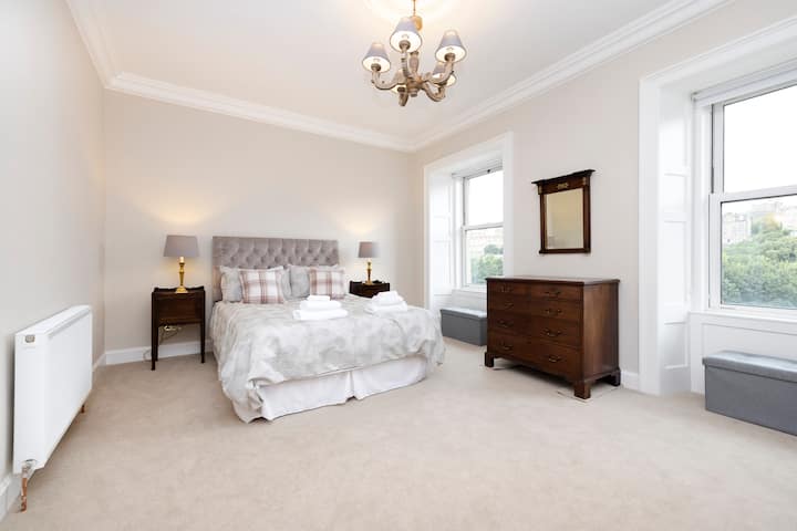 El dormitorio principal tiene un baño con ducha con mesita de noche y cajonera.