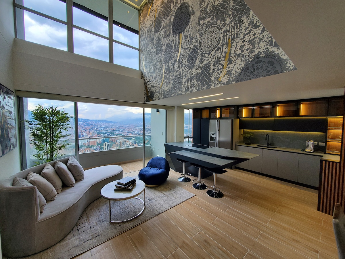 A modern living area features a curved sofa facing large glass windows that present sweeping views of the city. A round coffee table is positioned on a textured rug, while a sleek dining table with high-backed chairs is located nearby, showcasing elegant finishes.