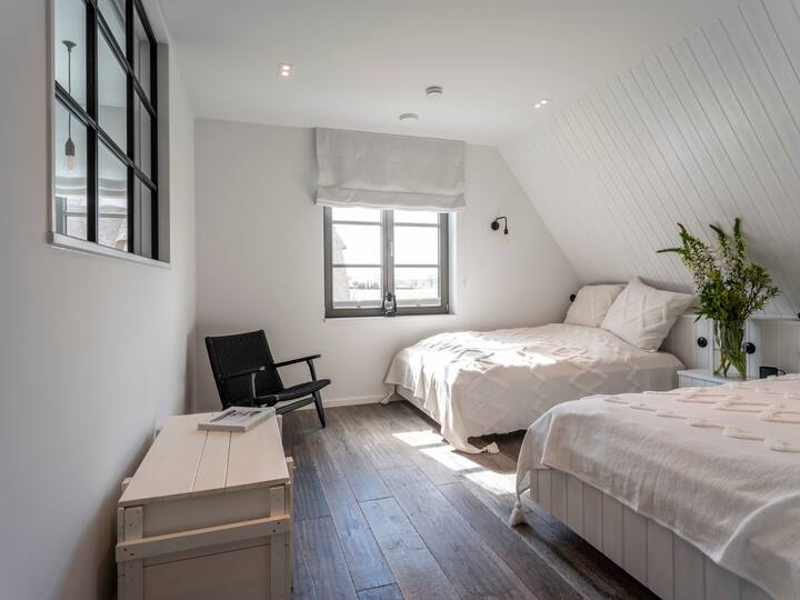 غرفة نوم بسريرين مفردين كبيرين (120 × 200 سم لكل منهما)، ومراتب مطاطية مناسبة للظهر، ووسائد رأس مطاطية، ونوافذ تعتيم