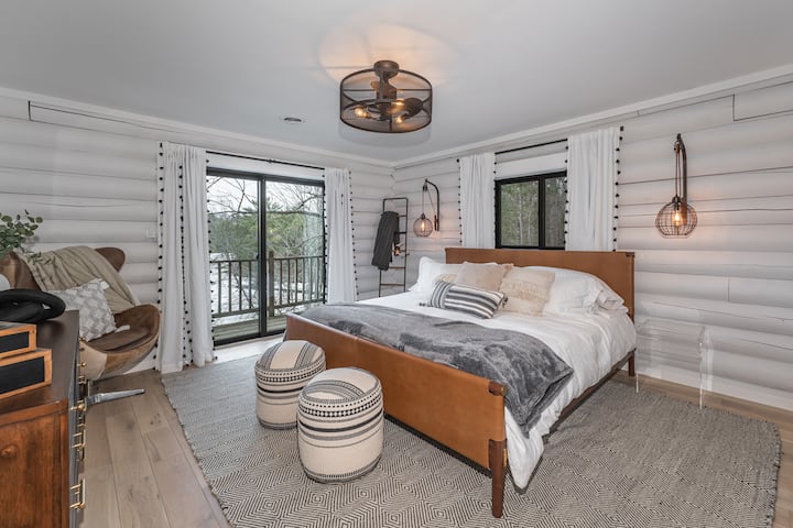 Dormitorio #1 con cama king, balcón extenso, televisión, armario personalizado, vistas al lago y al bosque