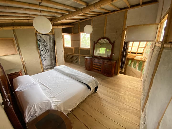 Spacious room overlooking the ranch landscape from the terrace and windows, with king-size bed.