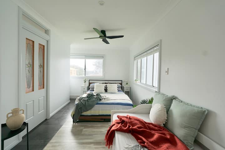 ห้องนอนใหญ่พร้อมเตียงควีนไซส์เตียงนอนเล่นและพัดลมเพดาน