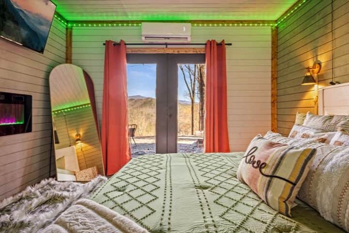 Cozy vibes in my bedroom with a comfy bed, a TV, and a view of the outside world.