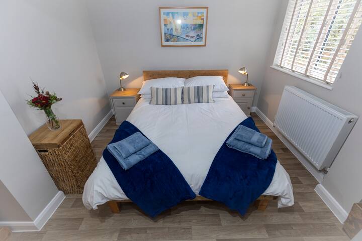 El dormitorio ofrece una cómoda cama doble con un edredón de plumas y una almohada para un lujo adicional.
