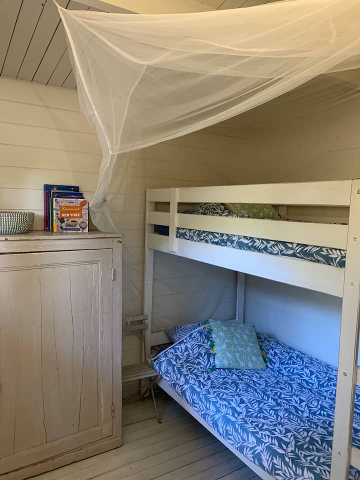 غرفة نوم مع أسرّة بطابقين وناموسية . البياضات مشمولة. أسرتك جاهزة عند الوصول 