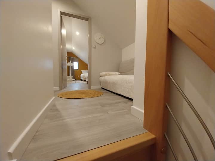 Პატარა დერეფანი სკამით, რომელიც მე ‑ 2 და მე ‑ 3 საძინებლებზე წვდომის საშუალებას იძლევა.