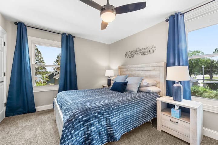 Primary bedroom with lake views, brand new Beautyrest Harmony queen mattress and adjustable base to tilt mattress up as desired on the top.  Room darkening curtains and ceiling fan.  Ultra comfort with Sealy firm and soft pillow on each side of bed.