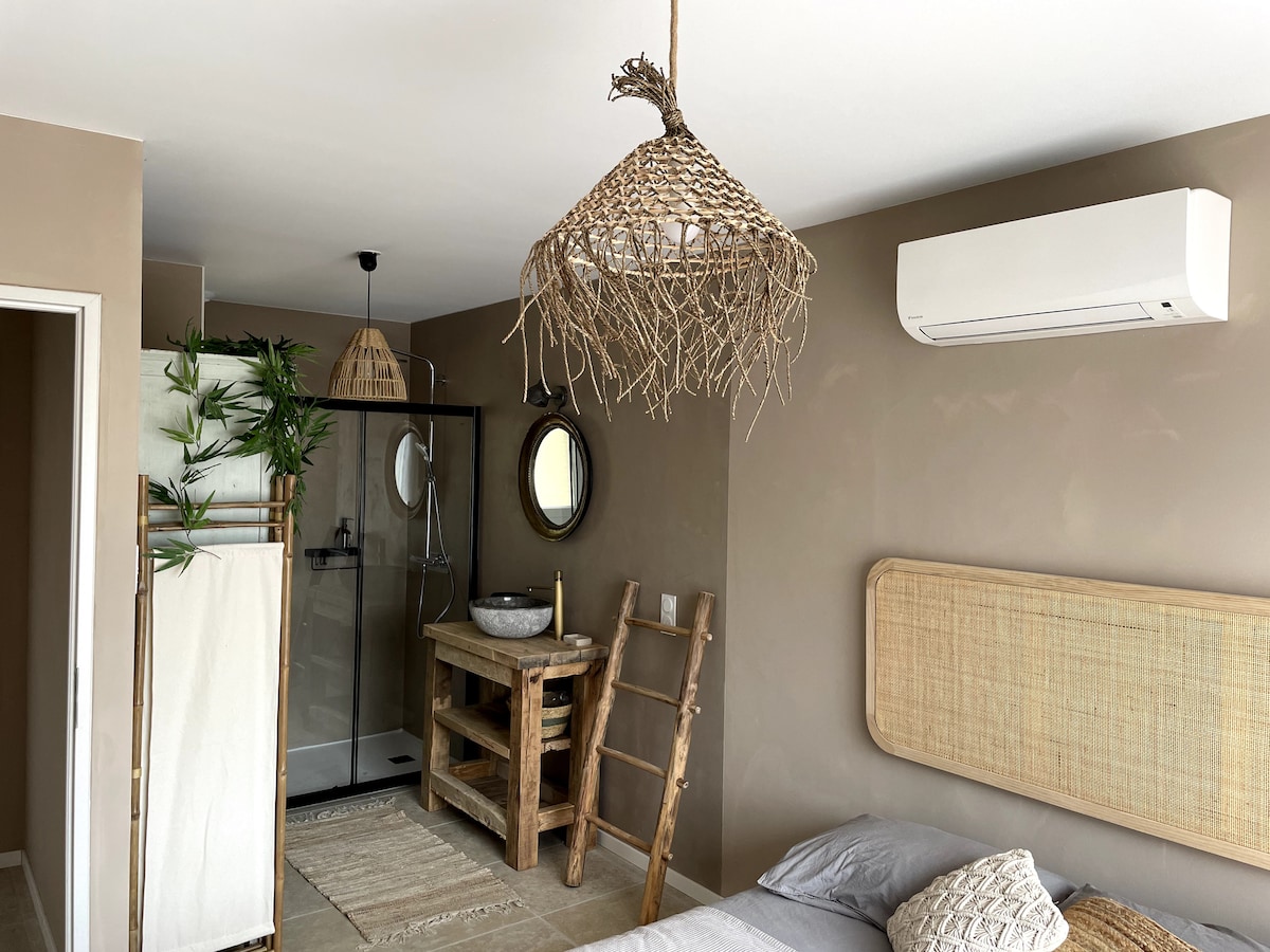 Chumba cha kupendeza katika mtindo wa bohemia, chenye bafu la wazi na mapambo ya asili, kinachofaa kwa mazingira ya starehe na ya kupumzika.