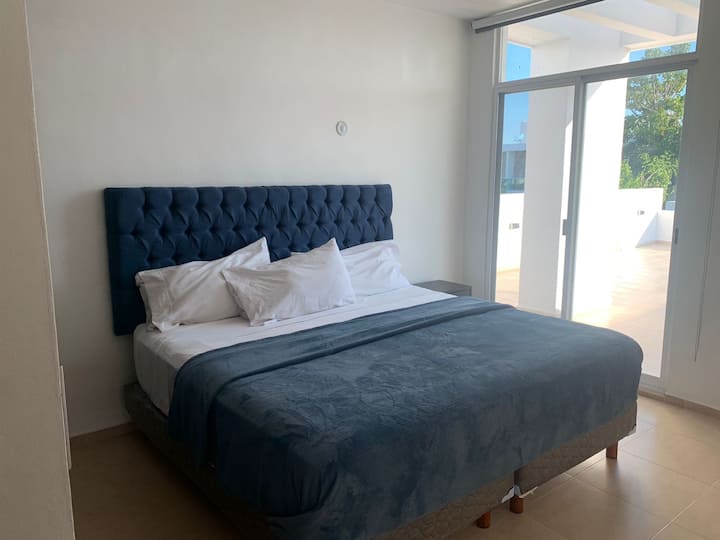 غرفة النوم الرئيسية سرير كينج الطابق الثاني، مع خزانة وتراس ومكيف ومروحة وتلفزيون.