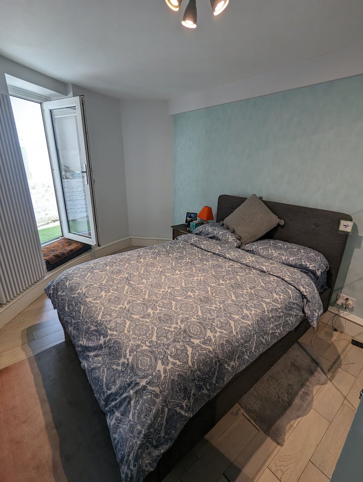 El dormitorio principal está diseñado en tranquilos azules y grises, con una puerta que proporciona un pasaje al jardín privado.