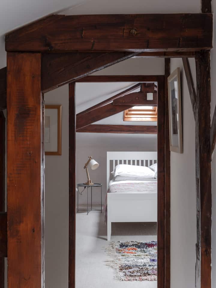 Vestíbulo en la planta superior y vista al dormitorio con cama tamaño king