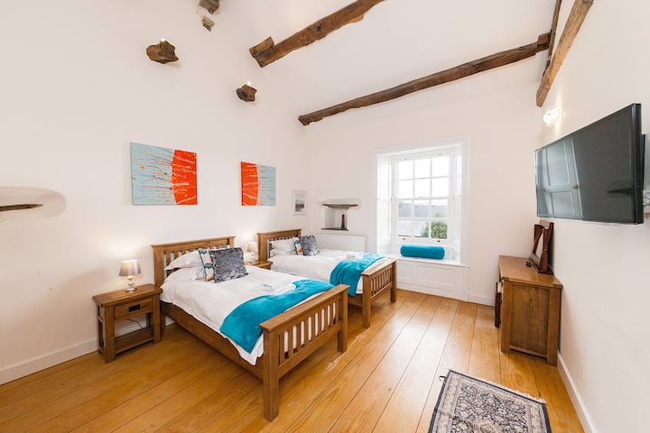 ベッドルーム2には、ツインベッド、窓シャッター、オリジナルの梁、手作りのキャビネット、スマートテレビが備わっています。