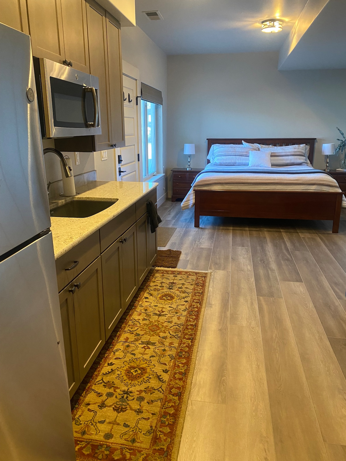 Cocina pequeña con nevera, microondas, horno tostador y fregadero.