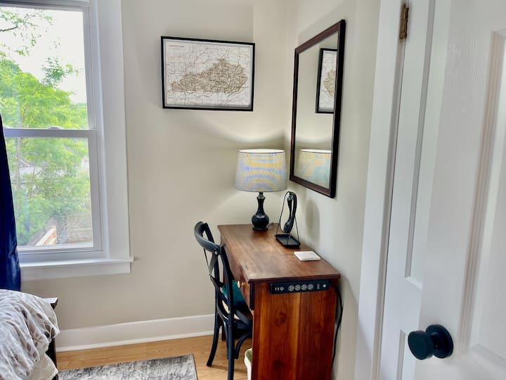 [Full] - The desk and or vanity space with a large mirror in the full-sized bed bedroom located next to a very small 1920's closet. Luggage racks are provided in the queen and kind bedrooms.