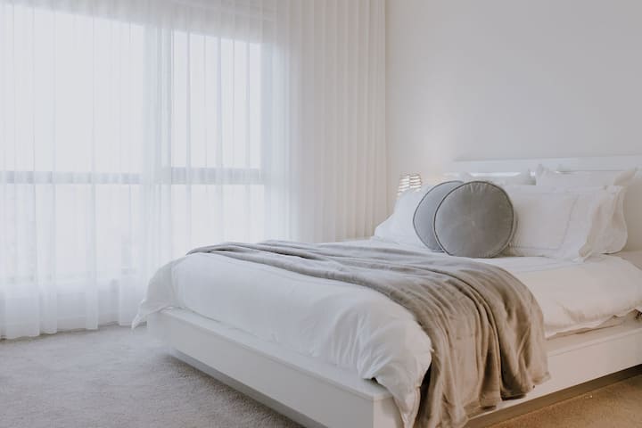 غرفة نوم رئيسية مع إطلالة على فتحة النفخ، مدمجة في خزانة ملابس وحمام داخلي - مرحاض ودش وغرور.